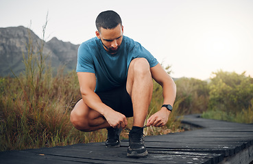 Image showing Hiking shoes, nature and man on trail to hike for wellness, health and exercise in the countryside. Forest, sports and healthy guy tying trekking boots on adventure walkway or path in South Africa.