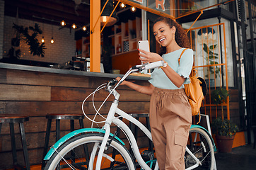 Image showing Woman, happy and bike with phone at cafe on travel in city with bag. Black woman, smartphone and smile for communication, meme or social media on app with bicycle at coffee shop in San Francisco