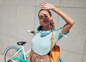 Image showing City, girl and hand shield for sun exposure on outdoor commute break at urban concrete wall. Young bike traveler woman hiding face from direct sunshine for shade protection in summer.