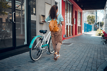 Image showing Bike, city and back view of black woman, walking on street or urban road outdoors. Exercise, fitness and female student on bicycle ride, eco friendly transportation and cycling on asphalt in town.