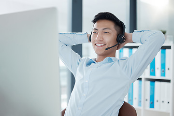 Image showing Asian man in call center office stretching, relax in easy working for customer support service company in Seoul..Telemarketing agent in corporate consulting, receptionist call and employee wellness