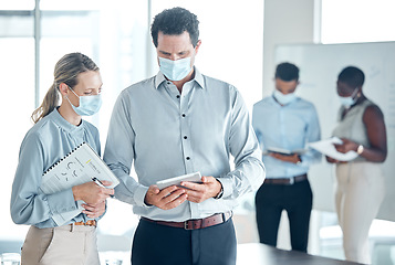 Image showing Office, man and woman mask, tablet and documents for planning, analytics and teamwork in advertising. People, discussion and technology in business during covid 19, coronavirus and pandemic in Berlin