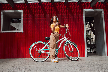 Image showing Woman, city bike and phone headphones for music, podcast of radio in Colombian travel. Smile, happy and fashion student or cool model with mobile, eco friendly and future environment energy transport