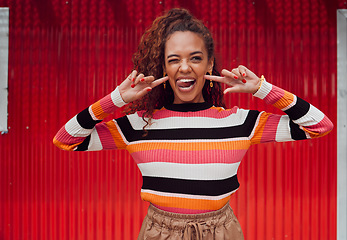 Image showing Funny face, happy and black woman with a smile and tongue out with trendy fashion style against a red background. Crazy chic with comic expression while feeling silly, happy and playful outside