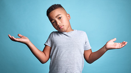 Image showing .Doubt, question and shrug from child with confused facial expression, dont know gesture and raised hands. Young boy, African youth and face portrait of puzzled black kid isolated on blue background.