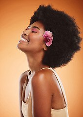 Image showing Beauty, skincare and makeup with a model black woman in studio on an orange background with an afro and smile. Face, hair and happy with an attractive young female posing for cosmetics or wellness