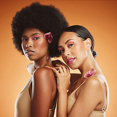 Image showing Flowers, makeup and women with skincare for face against a brown mockup studio background. Portrait of African model friends with natural orchid plants for spring, beauty and cosmetics for calm