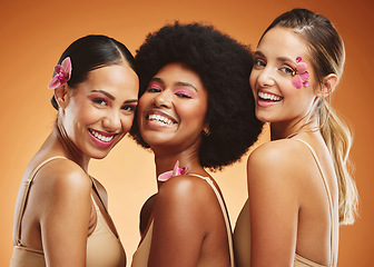 Image showing Beauty, diversity and smile with women and flowers for makeup, cosmetics and wellness. Tropical, natural and luxury with model in brown background for summer, creative and spa skincare treatment