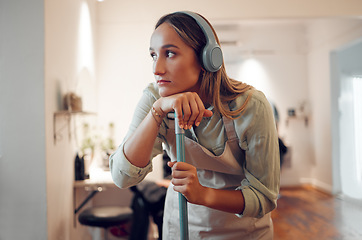 Image showing Woman, tired and cleaning with headphones for music while working in room at house. Cleaner, thinking and contemplating while listen to radio, podcast or song for rest at work, exhausted and burnout