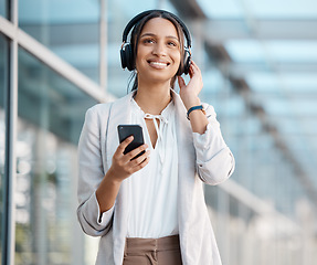 Image showing Woman, smartphone and headphones listening to music, radio or podcast on break in cityscape. Young professional, business person and streaming online service, audiobook and subscription playlist.