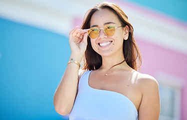 Image showing Summer, fashion and sunglasses, style and woman while happy in urban and cityscape. Young, Asian model and stylish accessories, gen z travel and vacation, trendy and fashionable in the street.