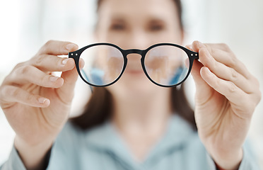 Image showing Eyes, vision and glasses with the hands of a woman optometrist holding spectacles during an eye test or exam. Frame, medical and insurance with a female optician showing prescription eyewear