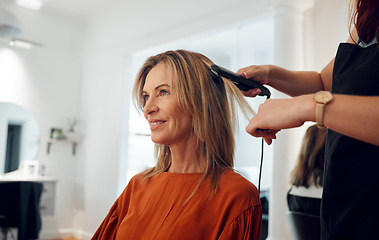 Image showing Hairdresser, flat iron and woman in salon for hair appointment with happy customer. Stylist using hair straightener on client in beauty salon or hair shop for straight hair, heat treatment and style