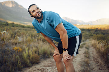 Image showing Running, fitness and man thinking in nature while training in countryside for health. Athlete runner with smile, motivation and idea on a run on a dirt path or field for exercise, workout and cardio