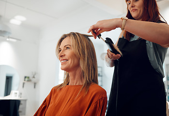 Image showing Salon, haircut and style with a woman customer straightening her hair for beauty or wellness. Fashion, client and hair with a female hairdresser or beautician at work with a consumer for haircare