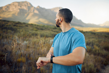 Image showing Fitness, man and runner with view of mountain in nature for healthy exercise or workout in the outdoors. Active athletic male training in sports run checking time on watch in the countryside
