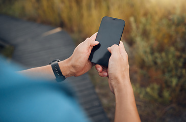 Image showing Fitness, hands and mockup phone screen of runner exercising in nature. Technology, digital tracking and man using smartphone doing training exercise, workout and running on mountain with smart tech