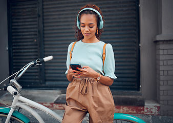 Image showing Phone, music and black woman cycling with a bike in the city of Australia for travel, adventure and to relax. Young, urban and African girl on social media with tech and a podcast riding a bicycle