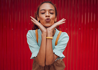 Image showing Fashion, kiss and black woman being playful against a red wall in the city of Norway for travel. Face of a young, happy and pouting girl with luxury makeup, clothes and happiness on an urban holiday