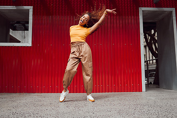 Image showing Dance, freedom and fun with a black woman on a red background, dancing or happy with a smile while moving to music. Dancer, free and expression with an attractive young female in rhythmic movement