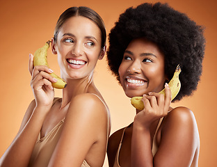 Image showing Beauty, diversity and women on banana phone, black woman and friend act, smile and fun pretending to be on phone call. Playful, friendship and studio portrait of happy girls with fruit and fake chat.