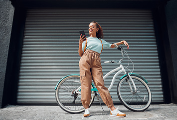 Image showing Bicycle, phone and black woman in city, street or urban road outdoors. Bike, travel and happy female from South Africa on 5g mobile tech, internet browsing or social media, web or online surfing.