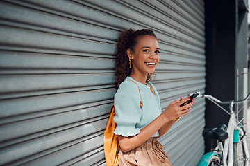 Image showing Phone, bike and black woman on wall in city, street or urban outdoors. Travel, bicycle and happy student from Nigeria on 5g mobile tech, social media or internet surfing, web browsing or text message