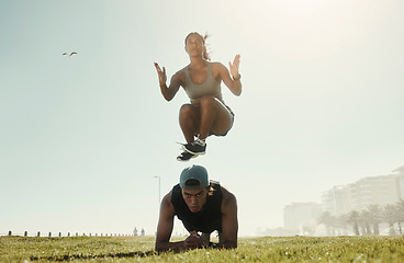 Image showing Energy, training and intense couple workout in a park with serious, cool and wellness in nature. Cross, different and fit jumping woman with man doing ground pushup in extreme physical exercise