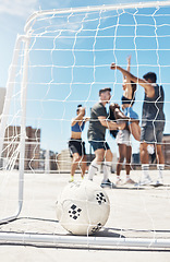 Image showing Football, soccer team and ball in goal post or net with diversity sports group of men and women in celebration of win, winning and scoring on urban rooftop. Exercise, concrete training and champions