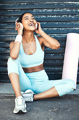Image showing Pilates, fitness and headphones of woman listening to music for wellness, gen z and healthy lifestyle. Happiness, excited and young sports girl training podcast motivation relax on floor in garage