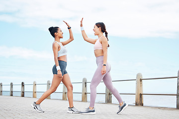 Image showing Fitness, friendship and high five, women on running path at the ocean for motivation, support and friends to workout together. Health, wellness and partnership success for girl and personal trainer.