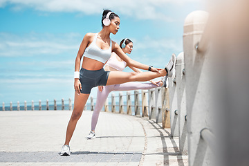 Image showing Runner, team and fitness women stretching for body health, self care or wellness on cardio run, exercise or marathon training. Start, running workout or girl friends prepare for sports run with music