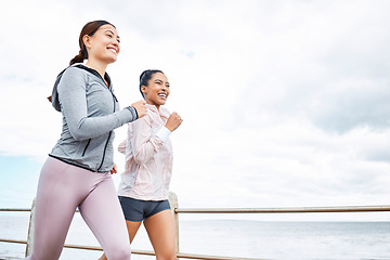 Image showing Friends, women and running by ocean, sea or promenade for wellness, fitness and health. Diversity, exercise and happy girls out for a run, cardio workout or training together outdoors by seashore.