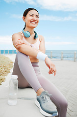 Image showing Fitness woman, happy and beach exercise while taking break or rest while out running on promenade with a positive mindset, motivation and goal. Happy asian athlete girl runner outdoor for a workout