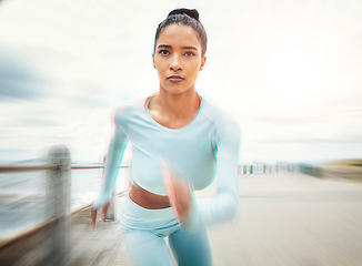 Image showing Woman, running and exercise motion blur by ocean, sea or promenade for health, fitness and wellness. Sports, runner and female from India out for run, training or cardio workout outdoors by seashore