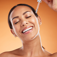 Image showing Face, skincare and beauty with a black woman using serum for antiaging on her skin in studio on an orange background. Health, wellness and cosmetics with a female applying a retinol treatment