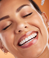 Image showing Face, skincare and serum with a model black woman using antiaging treatment on her skin in studio on an orange background. Beauty, cosmetics and skin with a young female applying retinol for health
