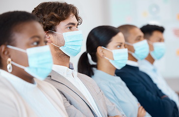 Image showing Covid, men and women with mask at seminar, tradeshow or presentation sitting in a row. Audience at trade show, conference or business meeting with face mask, focus and attention to health and safety.