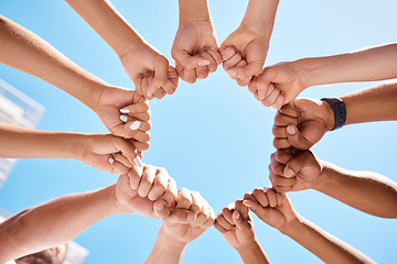 Image showing Fist hands, circle and community support diversity people, protest group and freedom fight on blue sky background. Below solidarity, teamwork and motivation for justice goal, trust and society power