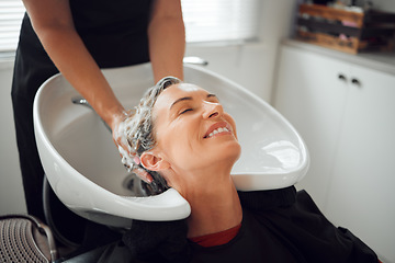 Image showing Hair, smile and wash, woman in salon relax with head back and hairdresser cleaning with shampoo and conditioner. Beauty, hair care and a luxury massage for client with professional stylist in spa.