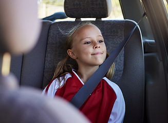 Image showing Girl child, road trip and seatbelt in car while smiling looking out the window on journey to sports match. Safety, smile and happy kid passenger on fun travel trip with transportation in Australia