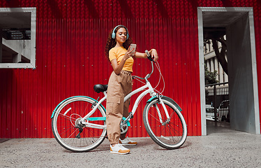 Image showing Woman, bike and phone in city travel with music headphones, 5g podcast or radio. Thinking model, mobile and fashion student on eco friendly, carbon footprint or future Colombian environment transport