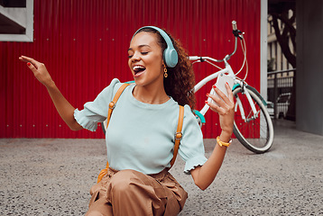 Image showing Headphones, music and happy woman singing in the city while streaming audio or radio online. Happiness, excited and girl from Puerto Rico listening to a track while sitting on pavement in urban town.