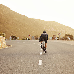 Image showing Fitness, cycling and sports man on a bicycle at sunset with mountain view in South Africa, exercise, freedom and health. .Road, cyclist and marathon training by athletic male on morning cardio ride