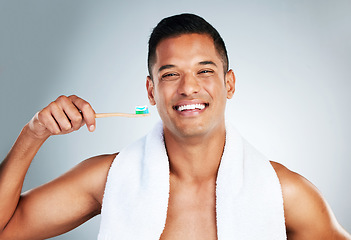 Image showing Mouth, dental and man brushing teeth in studio for hygiene, wellness and grooming against a grey background. Portrait, teeth and oral care by happy guy enjoying fresh, clean and toothpaste routine