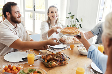 Image showing Big family, lunch and food in home dining room with people sharing a meal. Love, happy and relatives eating food, bread and delicious gourmet chicken on table while spending quality time together.