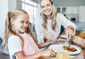 Image showing Children, family and food with a girl and mother eating a meal at the dining room table at home together. Kids, lunch and love with a woman and daughter sharing a roast in celebration of an event