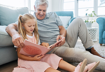 Image showing Book, family and children with a girl reading to her grandfather on the floor of their living at home. Kids, read and story with a senior man and granddaughter bonding in their house during a visit