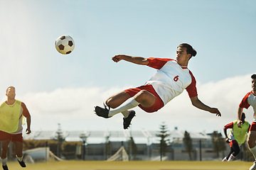 Image showing Soccer, game and man kicking a ball during training with the team on a field for sports. Athlete football player in the air to jump for a goal while playing in a professional match or competition
