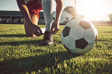 Image showing Fitness, shoes and soccer player ready for sports training, exercise and cardio workout on football field outdoors. Hands, footwear and athlete tying boots to start a practice game or match